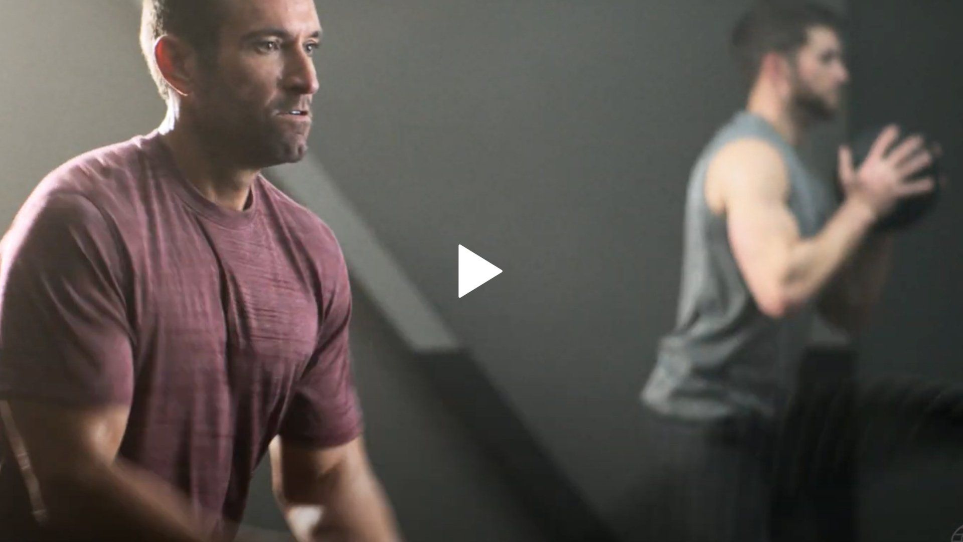 A man is standing in front of a mirror in a gym.