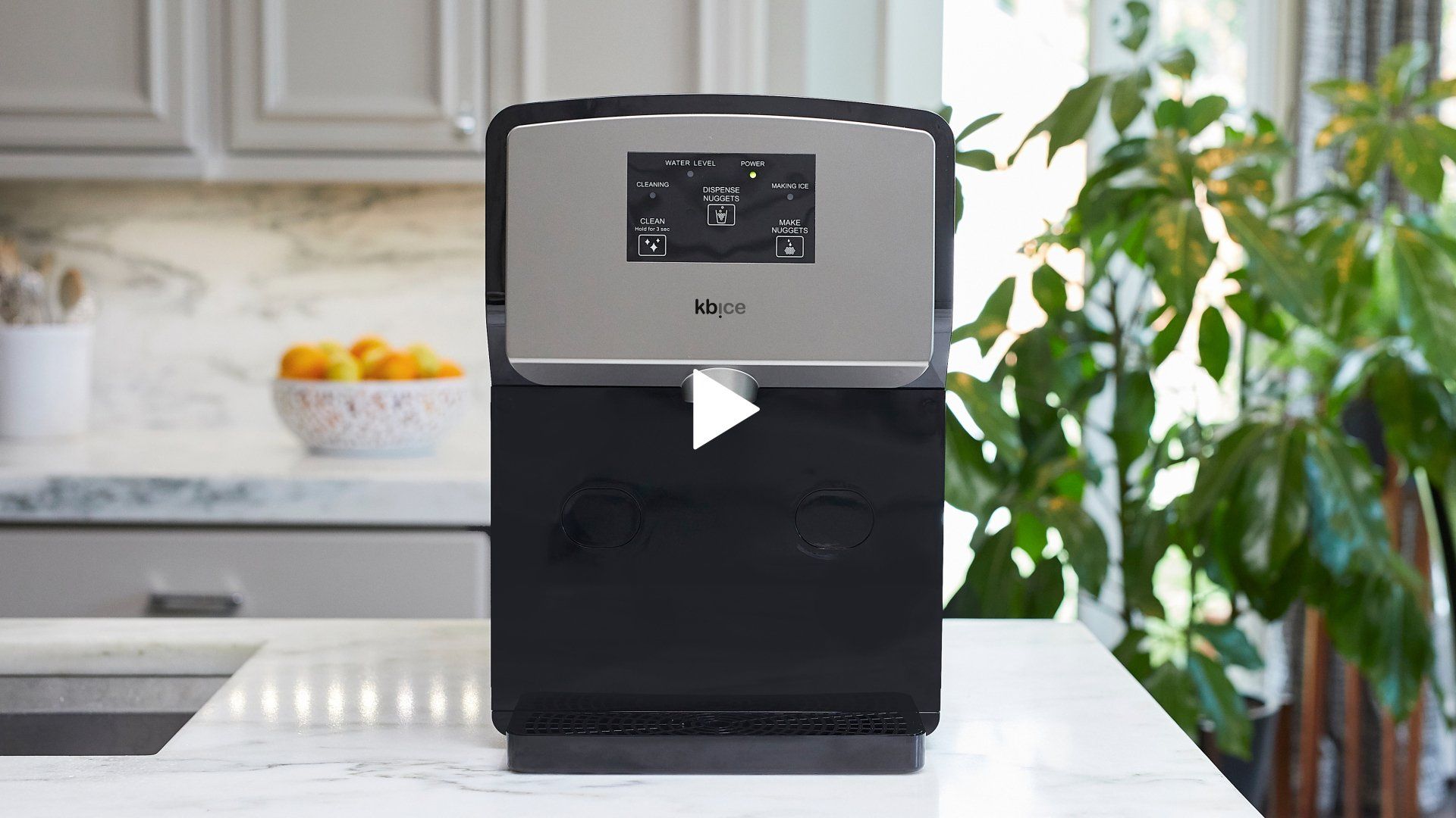A black and silver machine is sitting on a counter in a kitchen.
