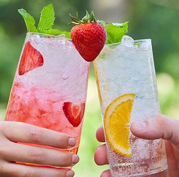 Two glasses with strawberries and orange slices on them