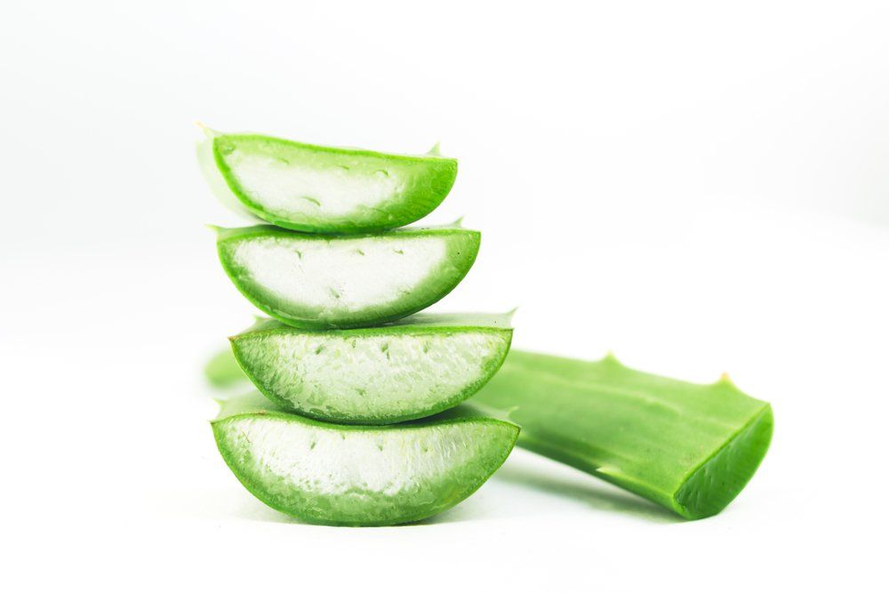Aloe-Vera-Scheiben sind auf einem weißen Hintergrund übereinander gestapelt.