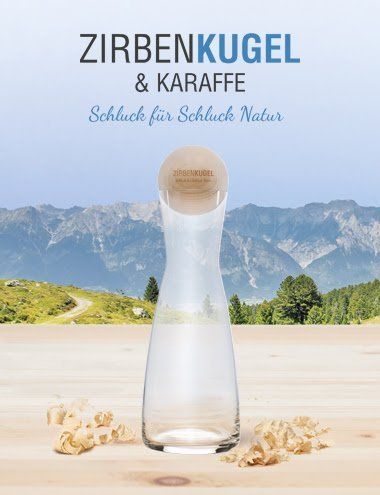 Auf einem Holztisch steht eine Glaskaraffe mit Holzdeckel.