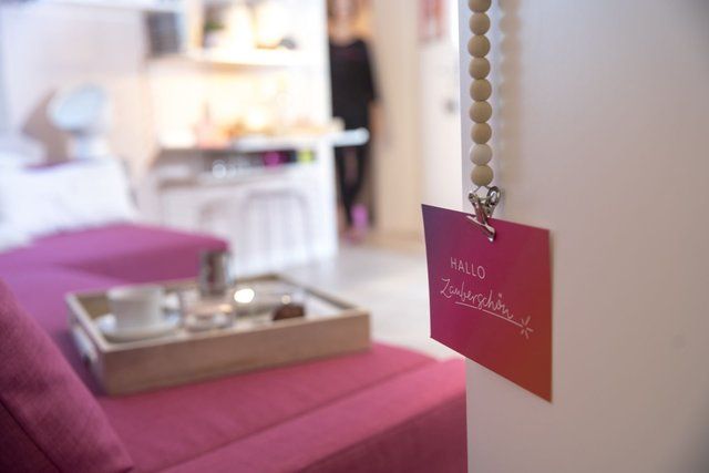 Ein rosa Sofa mit einem Tablett darauf und einem Schild mit der Aufschrift „Hallo alles“