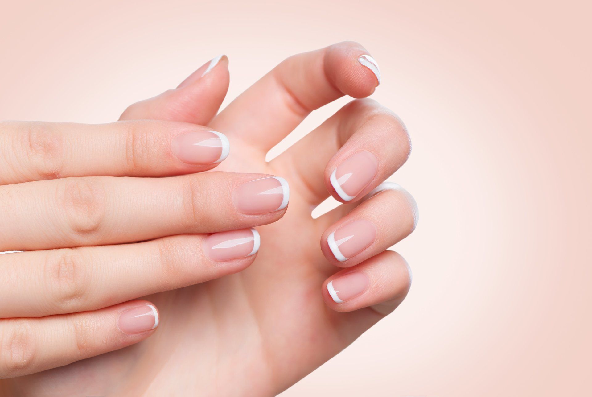 Eine Nahaufnahme der Hände einer Frau mit French Manicure.