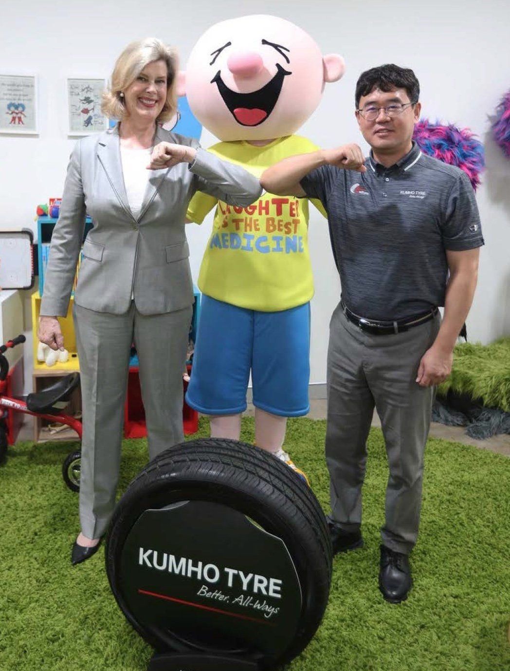 Kumho Tyres employees posing with the Camp Quality mascot