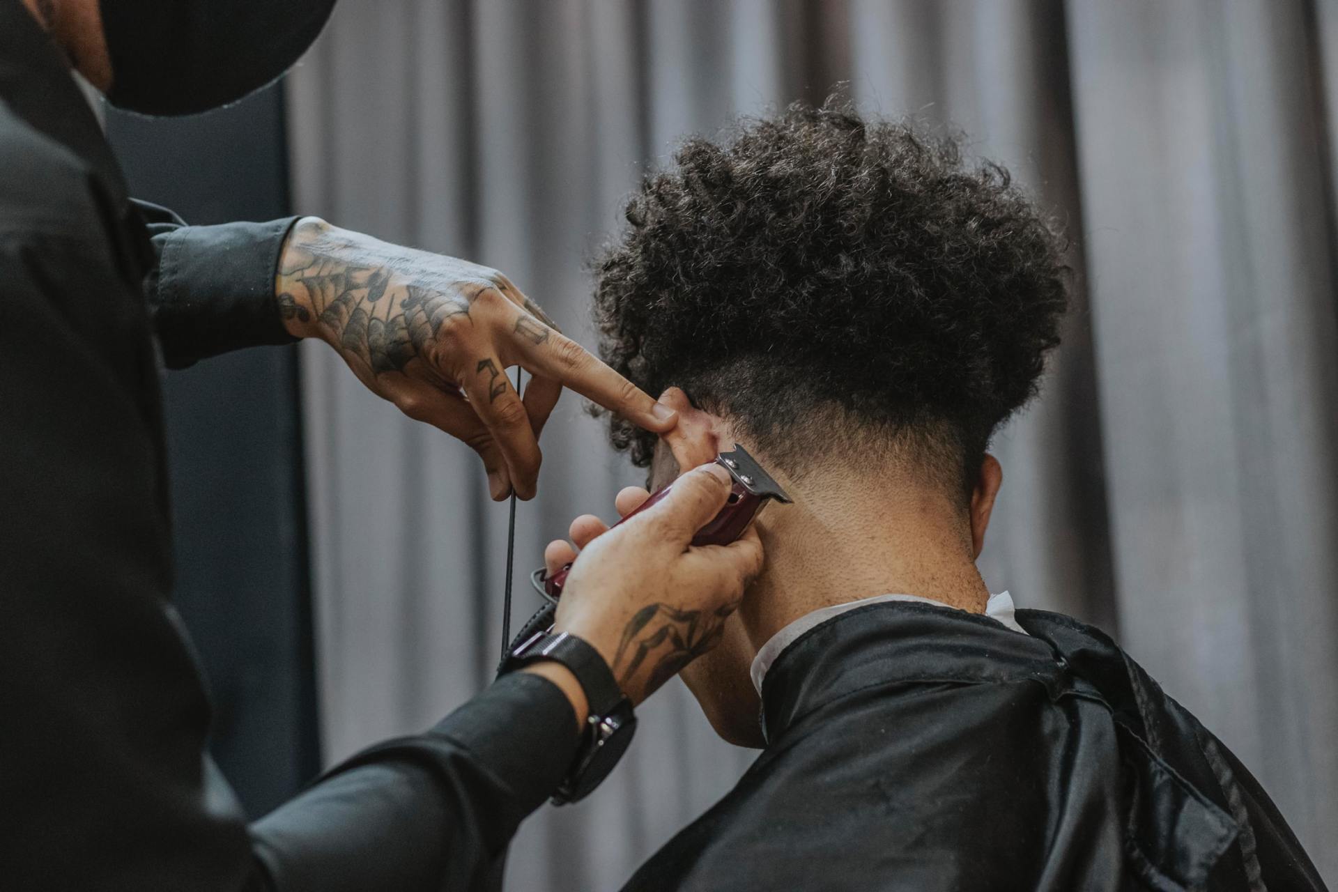 Un homme se fait couper les cheveux par un coiffeur dans un salon de coiffure.