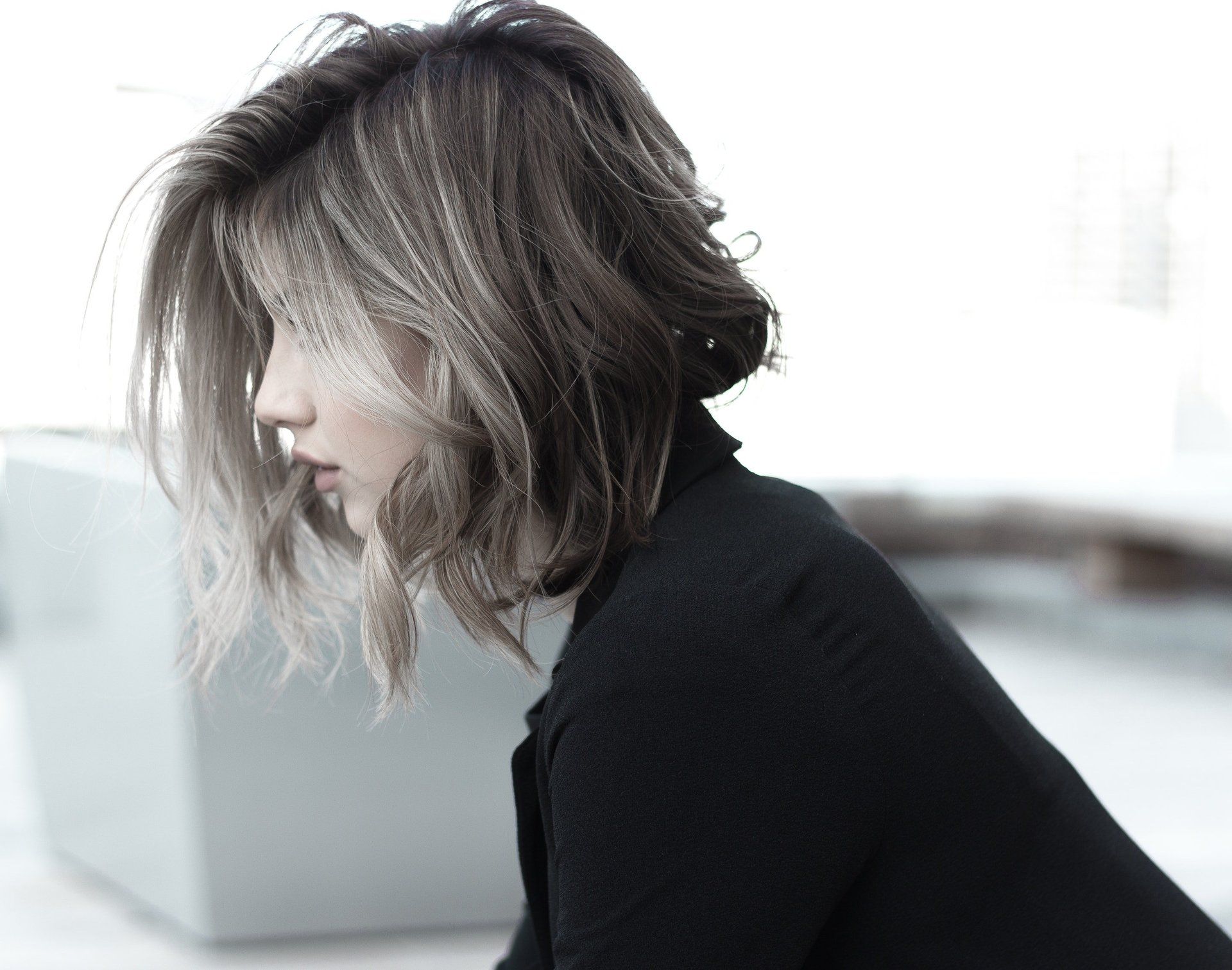 A woman with short hair is wearing a black sweater.