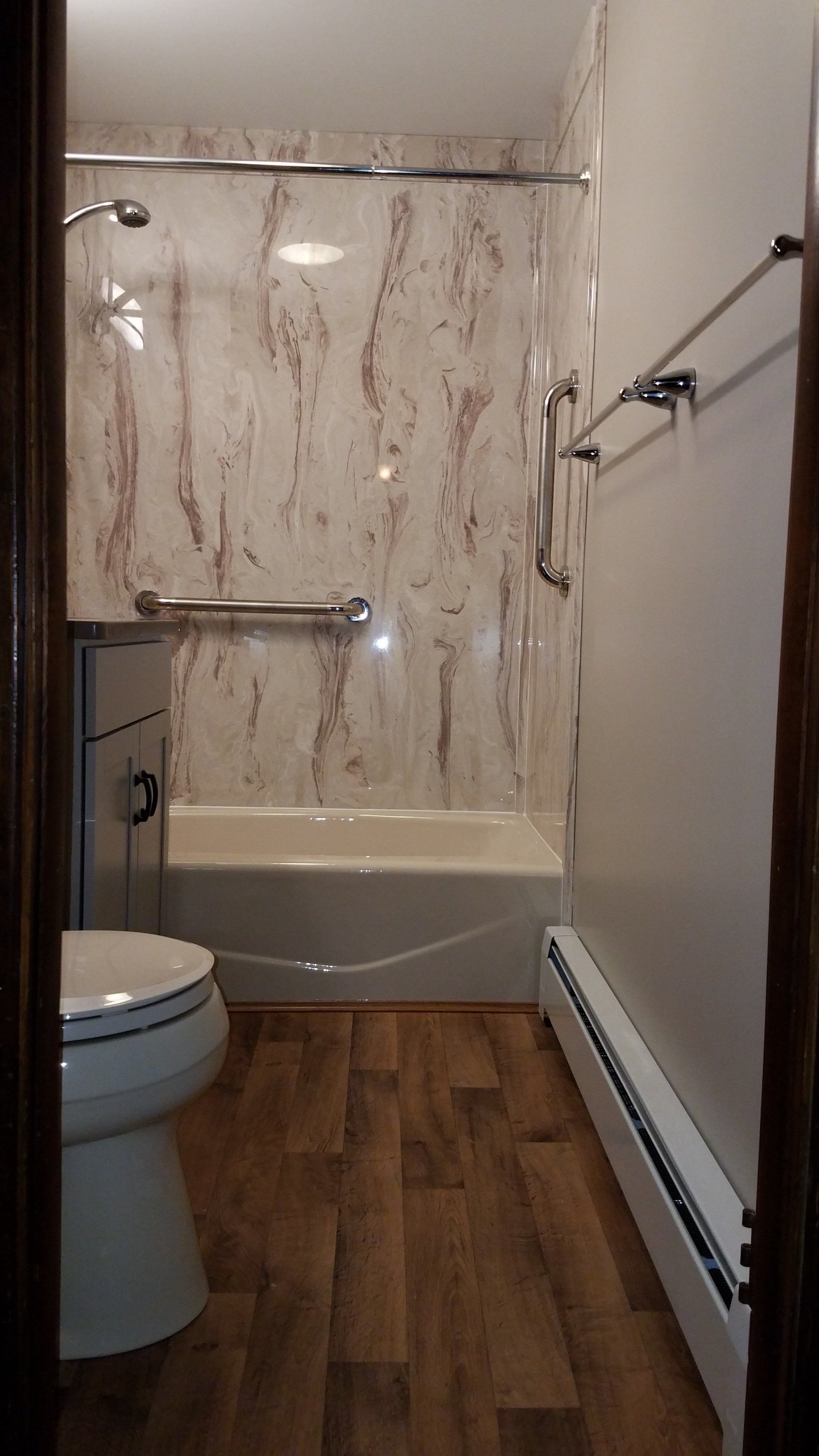A bathroom with a toilet , bathtub and shower.