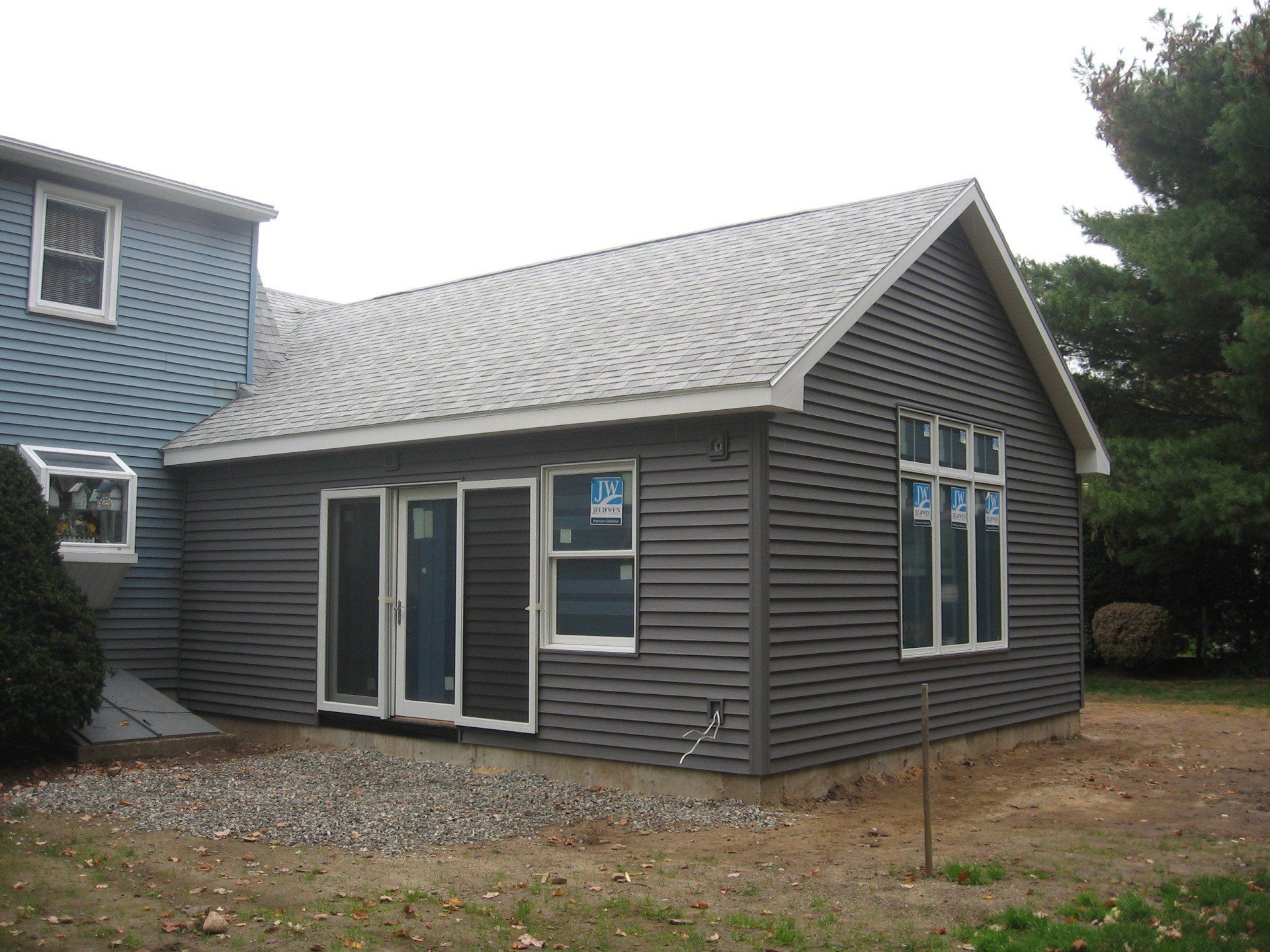 A house with a gray siding and a white roof