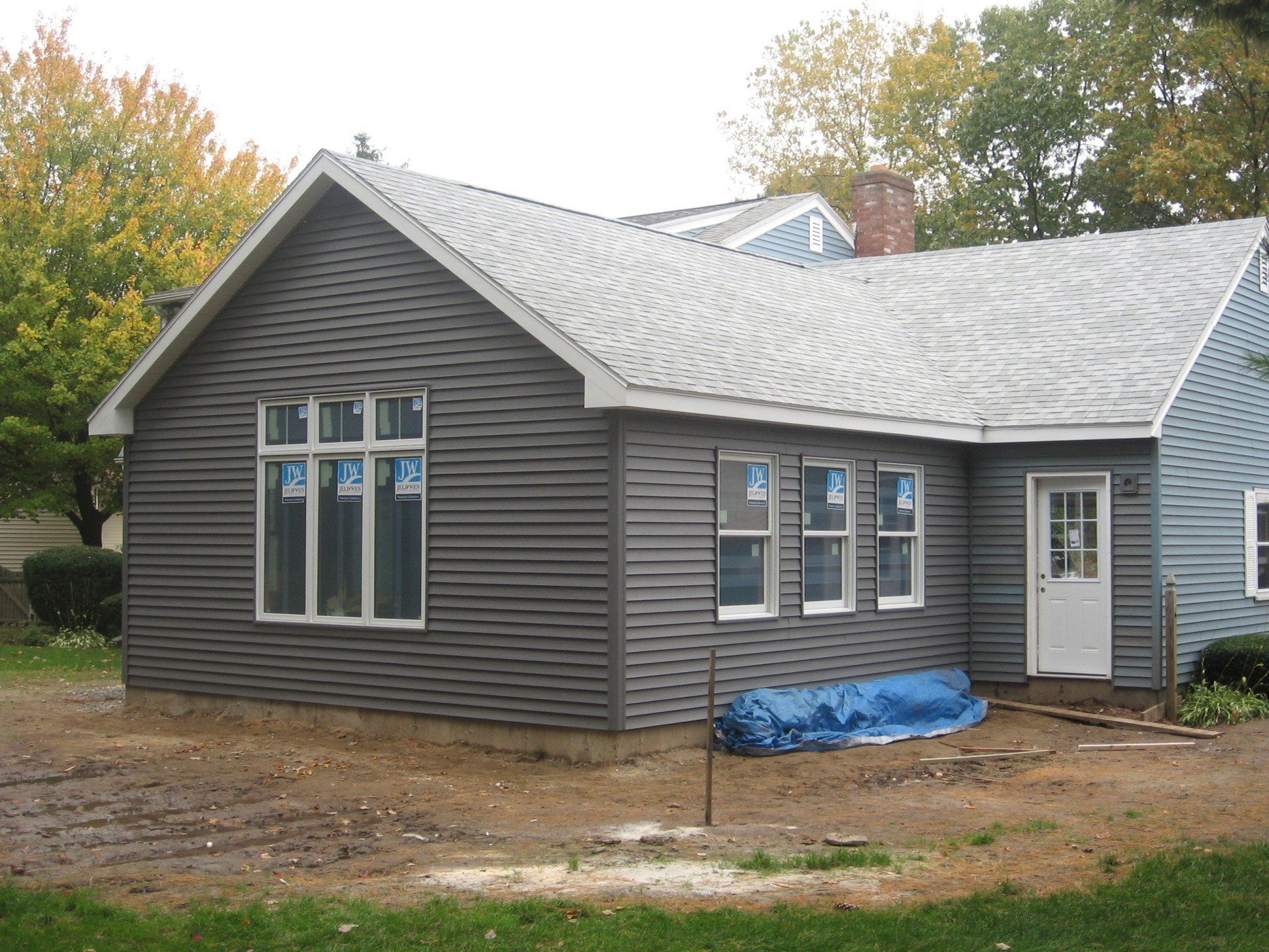 A gray house with a white door and windows