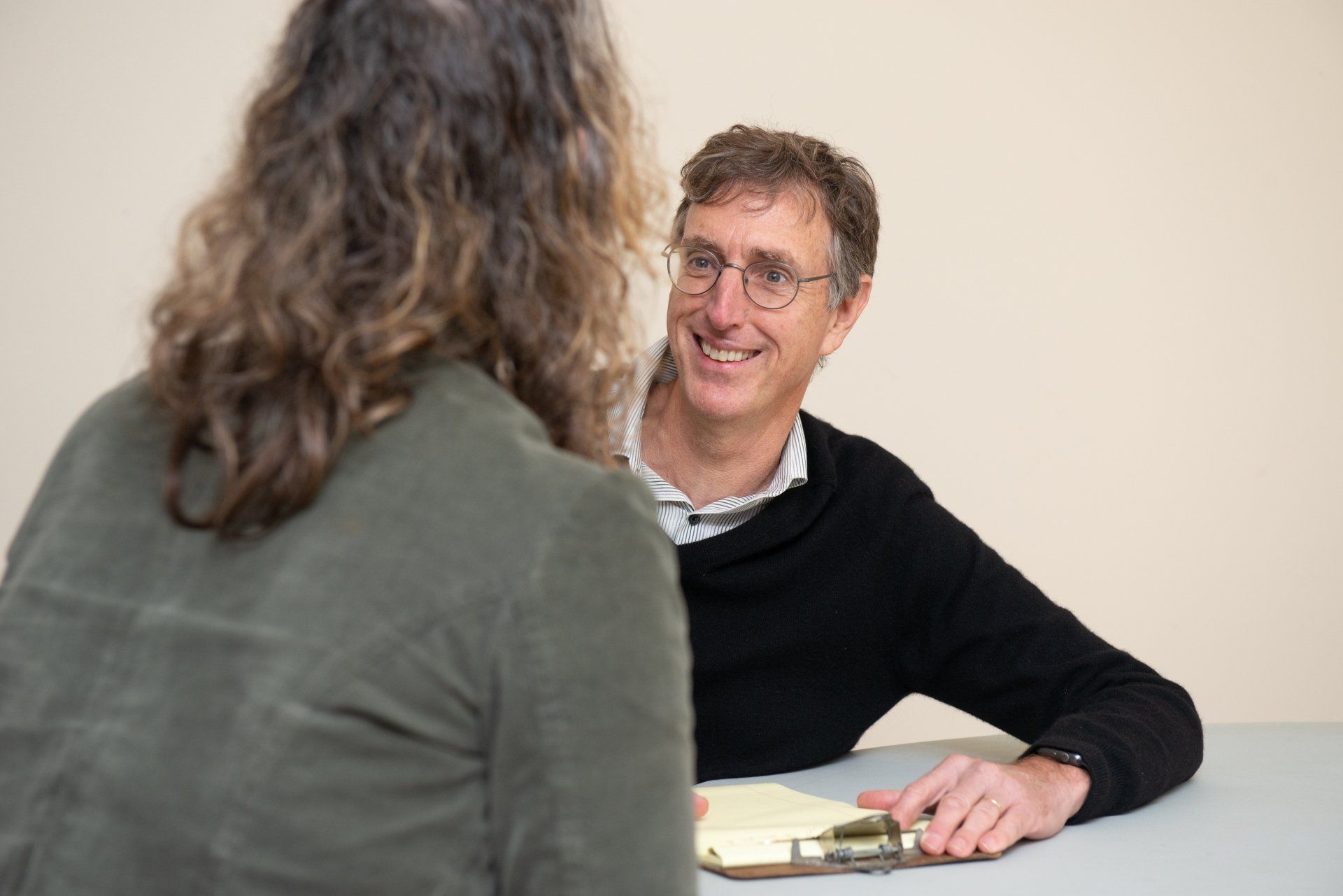 Greg Hessel is talking across a table from a client.