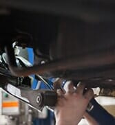 Man Working Under Car—Car Engine Repair in Salisbury, MA Man Working Under Car—Car Engine Repair in Salisbury, MA