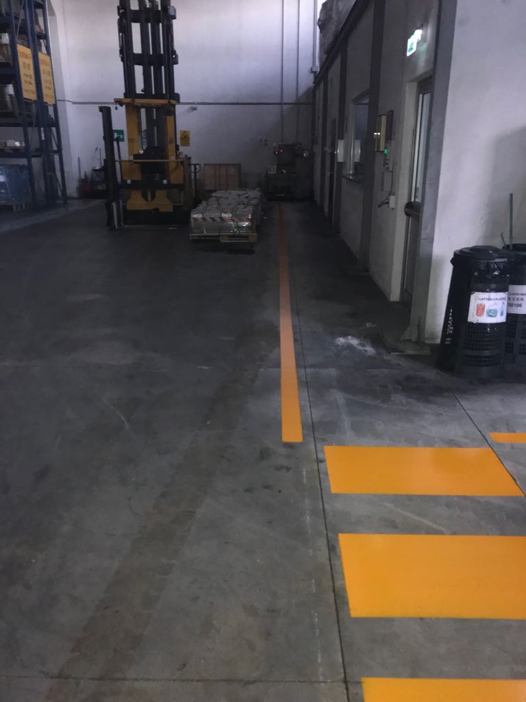 Segnaletica orizzontale in vernice gialla in un magazzino
