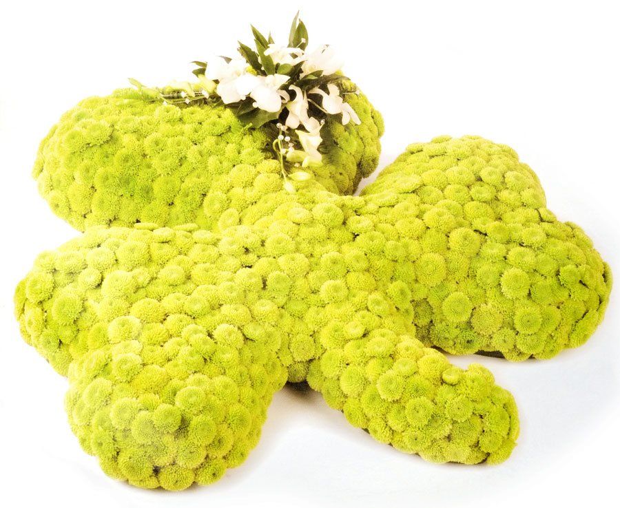 Green flower arrangement shaped like a four-leaf clover, white flowers in the center.