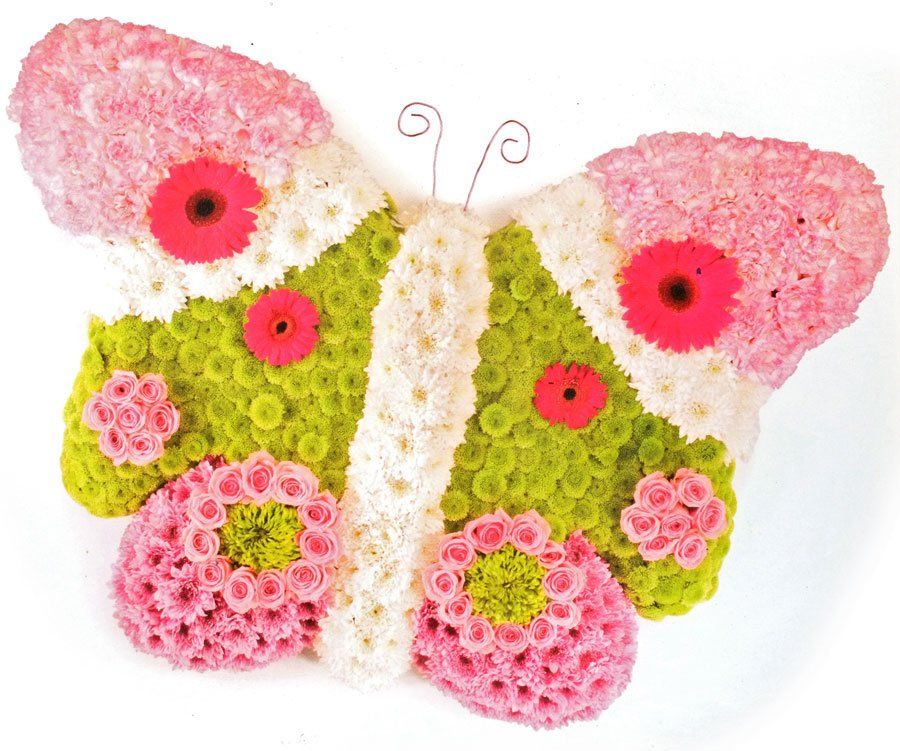 Floral arrangement shaped like a butterfly with pink, green, and white flowers, and red accents.