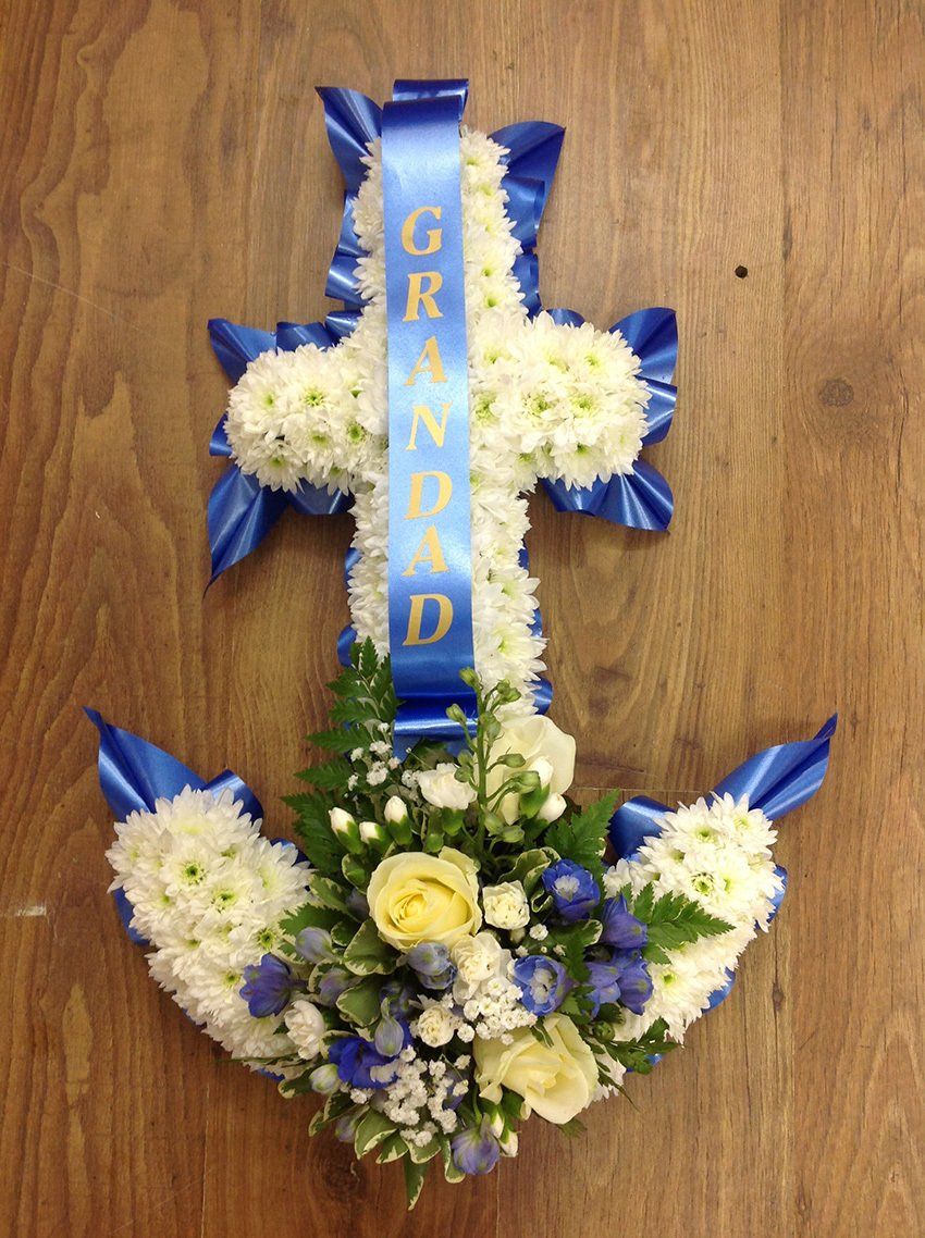 Floral anchor with cross top, white and blue flowers, ribbon says 
