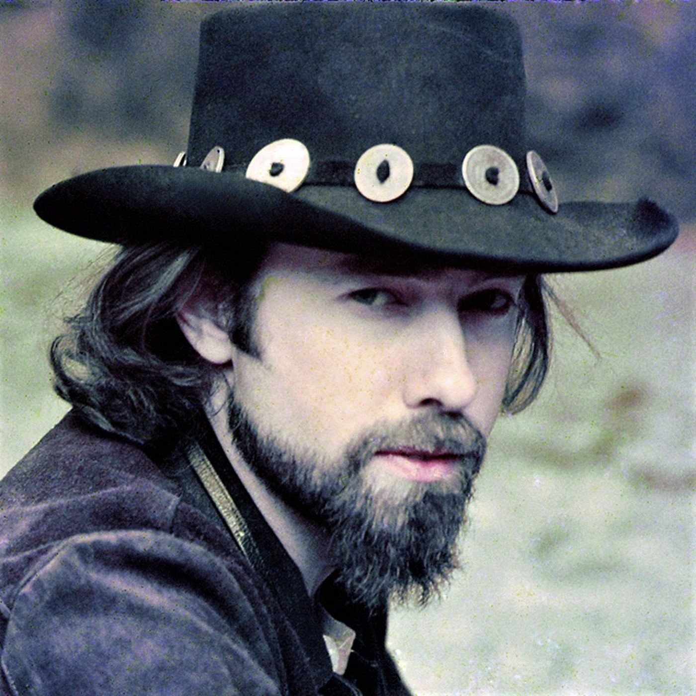 A man with a beard wearing a black cowboy hat