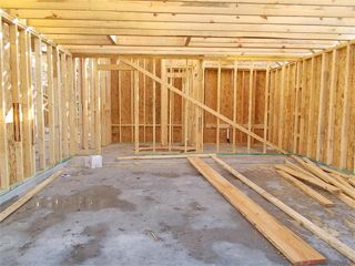 Interior of a building under construction, showing wooden framing and concrete floor.