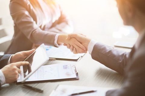 People shake hands finishing up an investment meeting