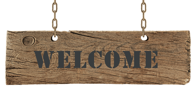 A wooden sign hanging from chains that says welcome