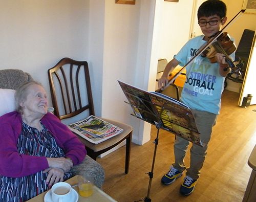 Young boy playing music for the elderly at the Long Sutton