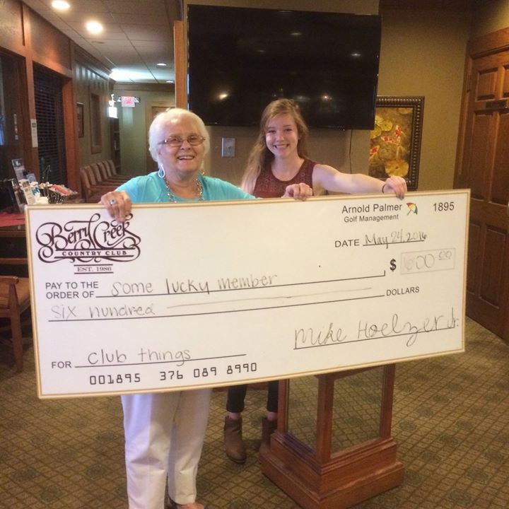 Two women holding a large check for $ 1000