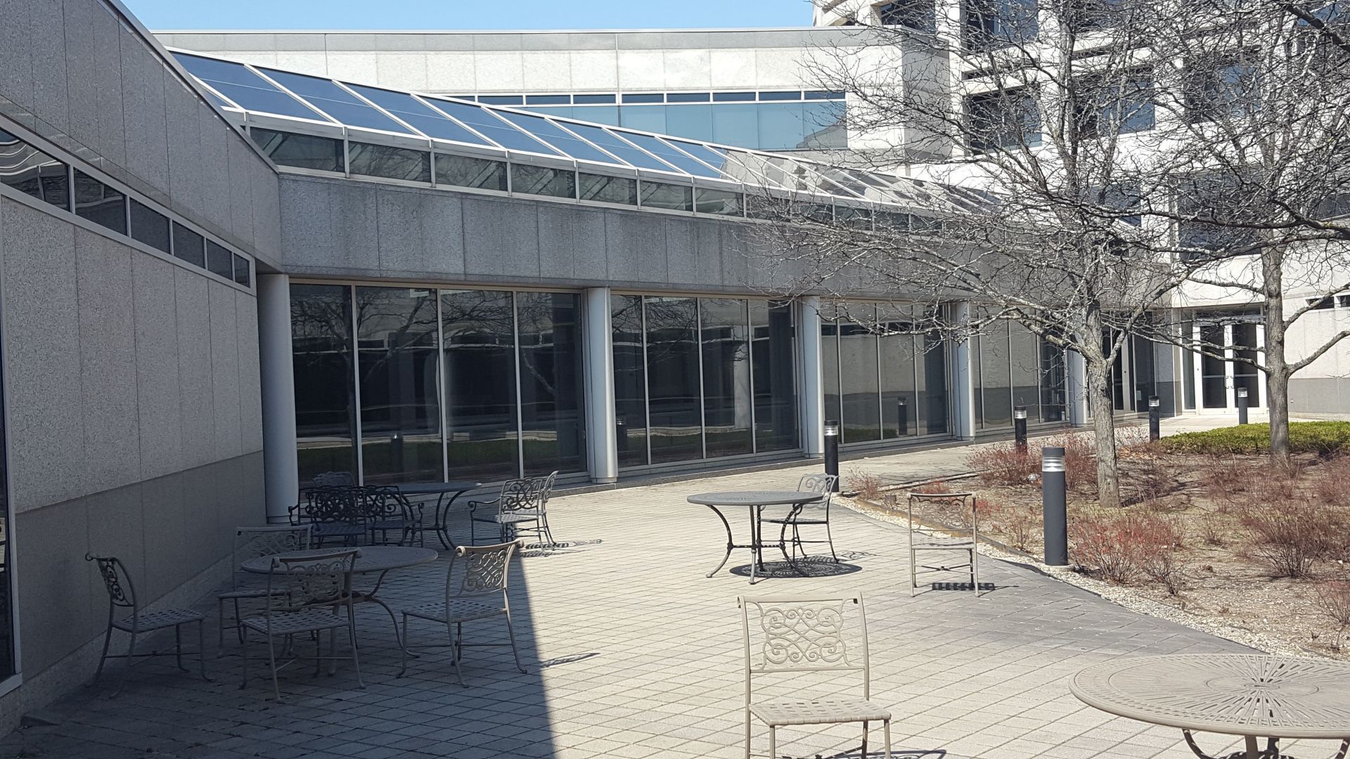 A courtyard with tables and chairs in front of a building.