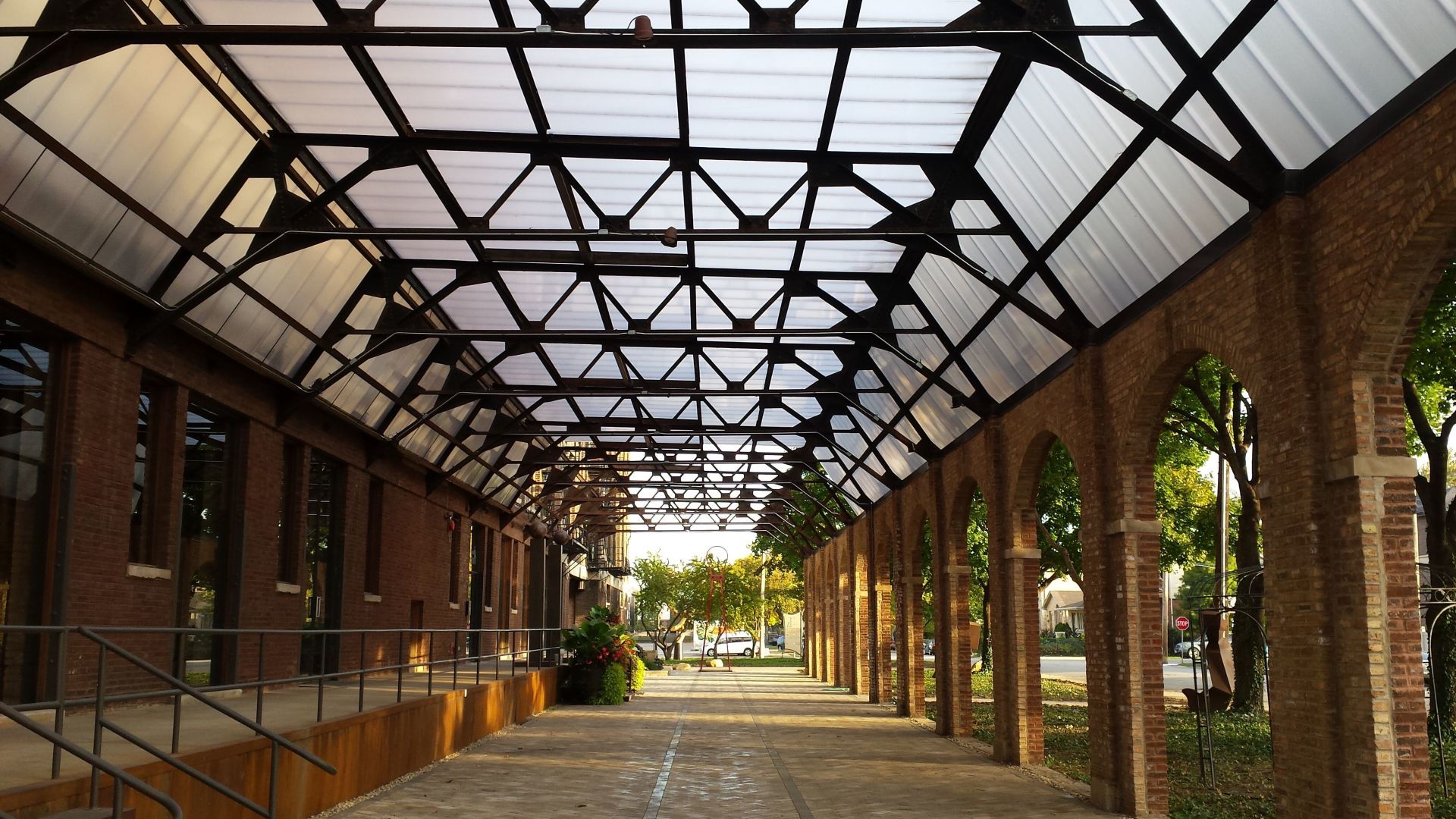 A long hallway with arches and a clear roof