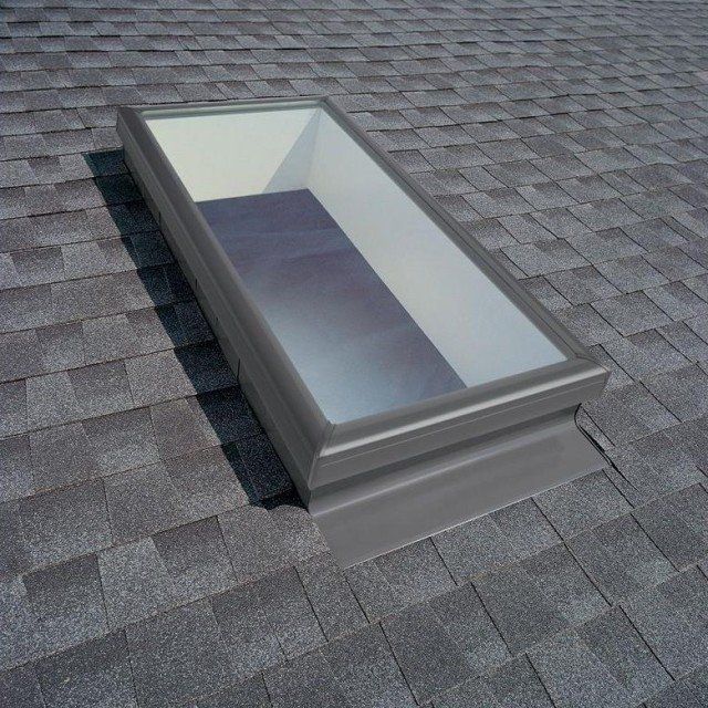 A skylight on top of a shingle roof