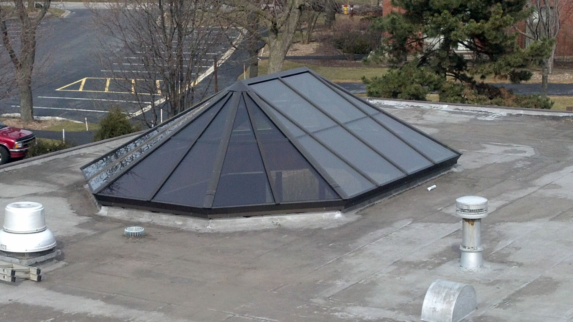 A roof with a pyramid shaped skylight on it