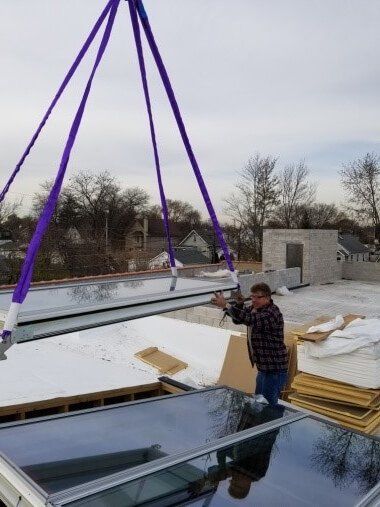 A man is working on a roof with a crane.
