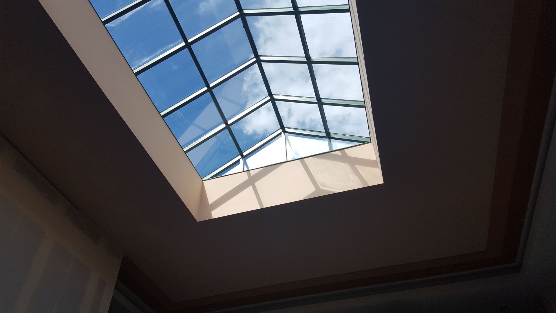 Looking up at a skylight with a blue sky in the background