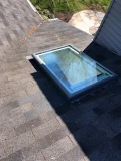 A skylight is sitting on top of a roof.