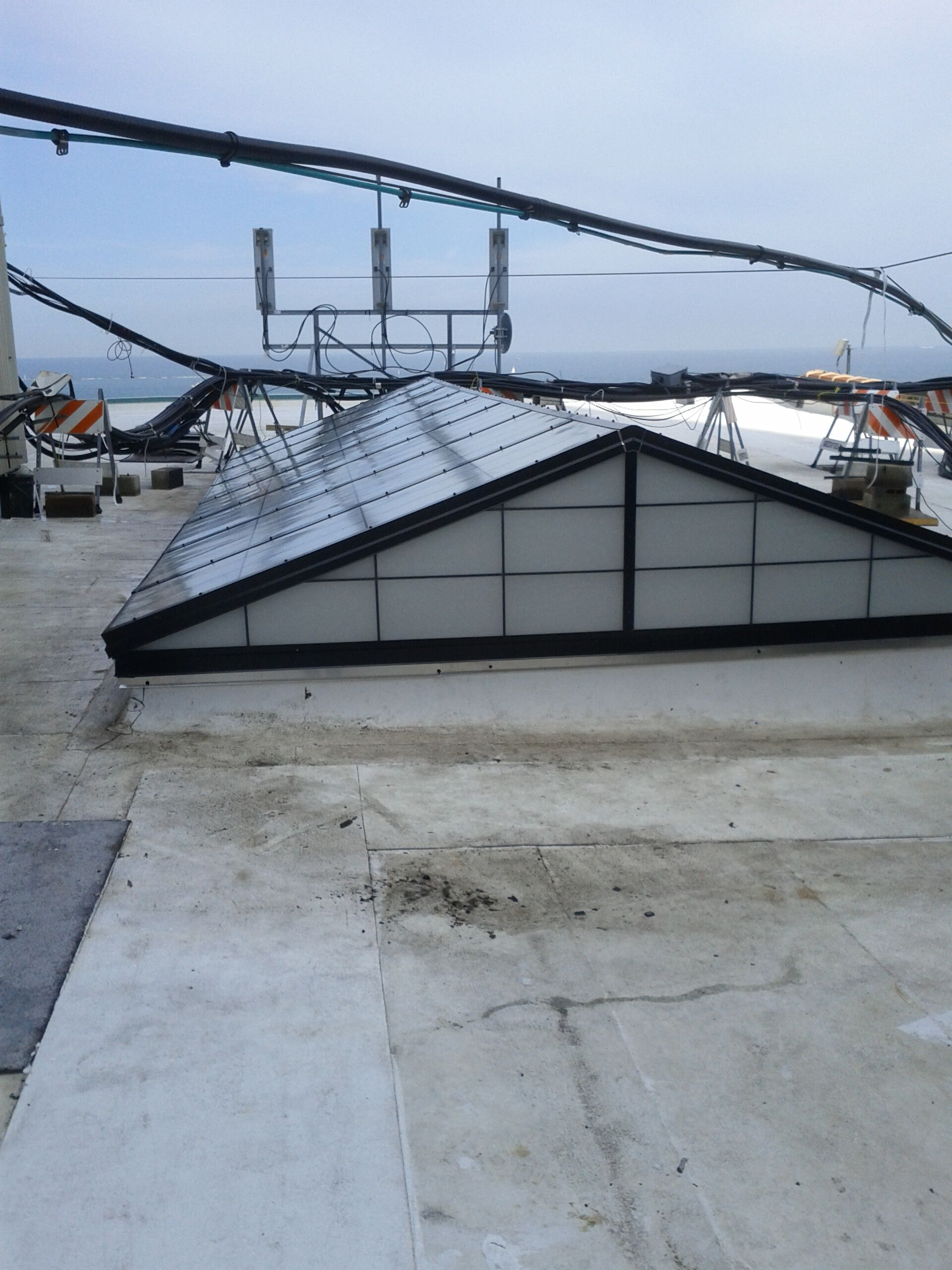 A roof with a skylight and antennas on it