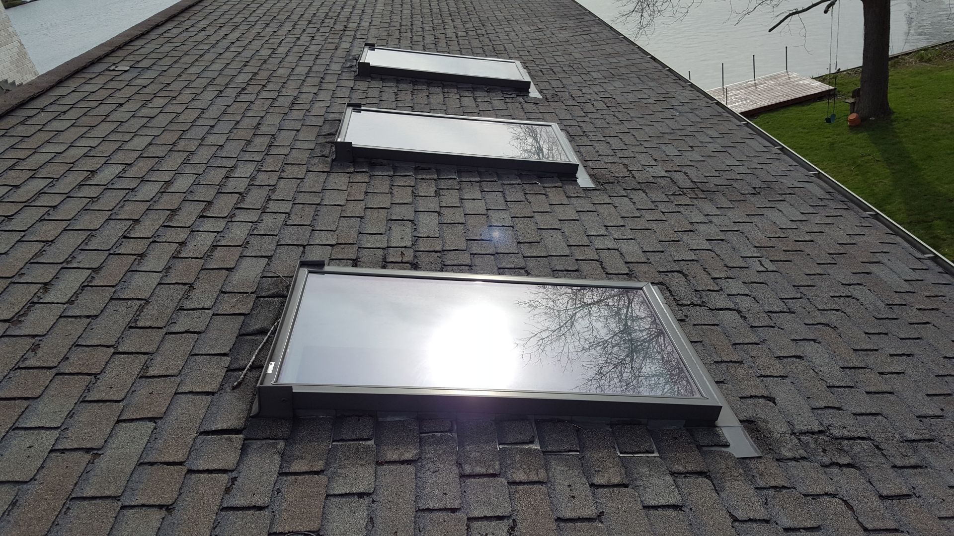 There are three skylights on the roof of a house.