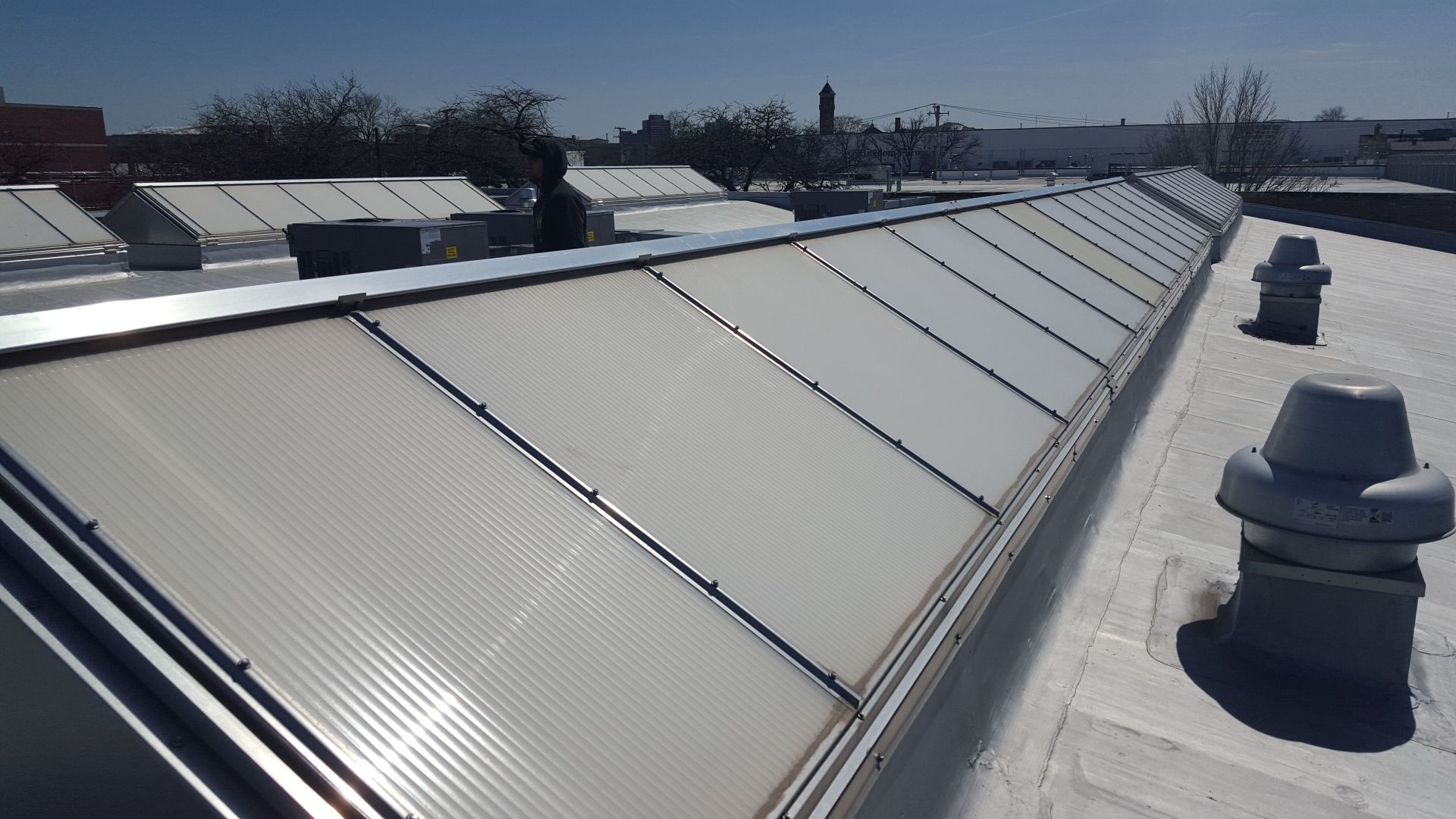A white roof with a lot of skylights on it
