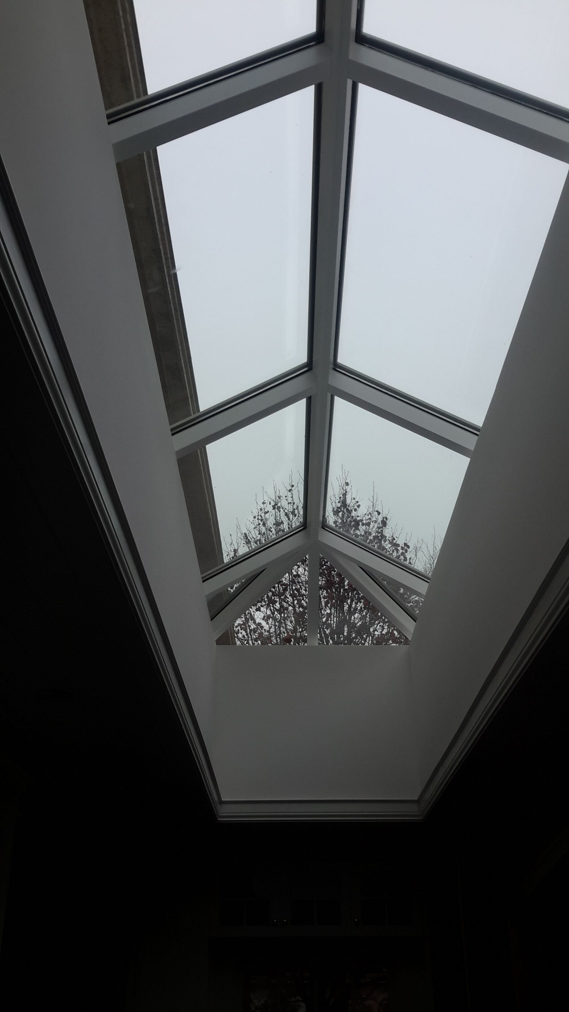 Looking up at the sky through a skylight in a building.