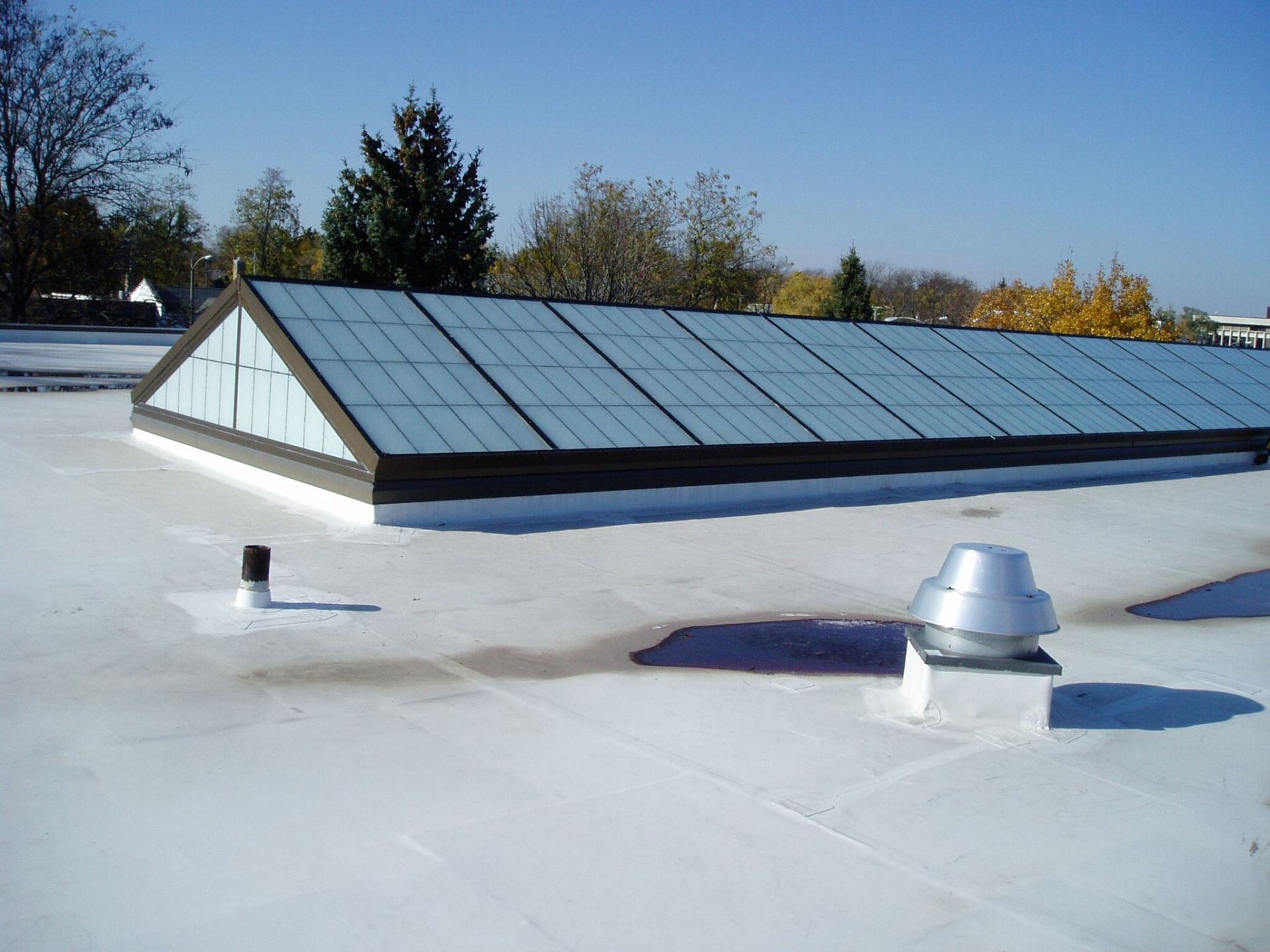A white roof with a skylight on top of it
