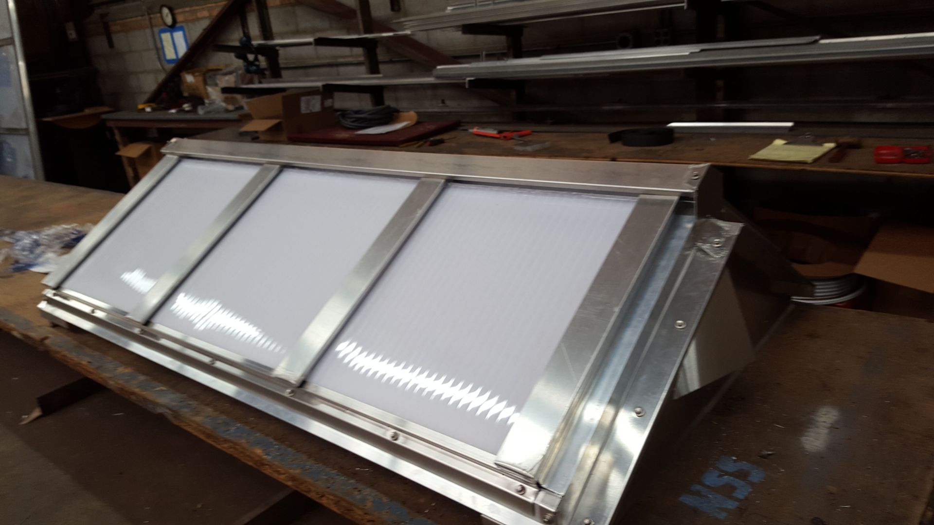 A stainless steel item is sitting on top of a wooden table.