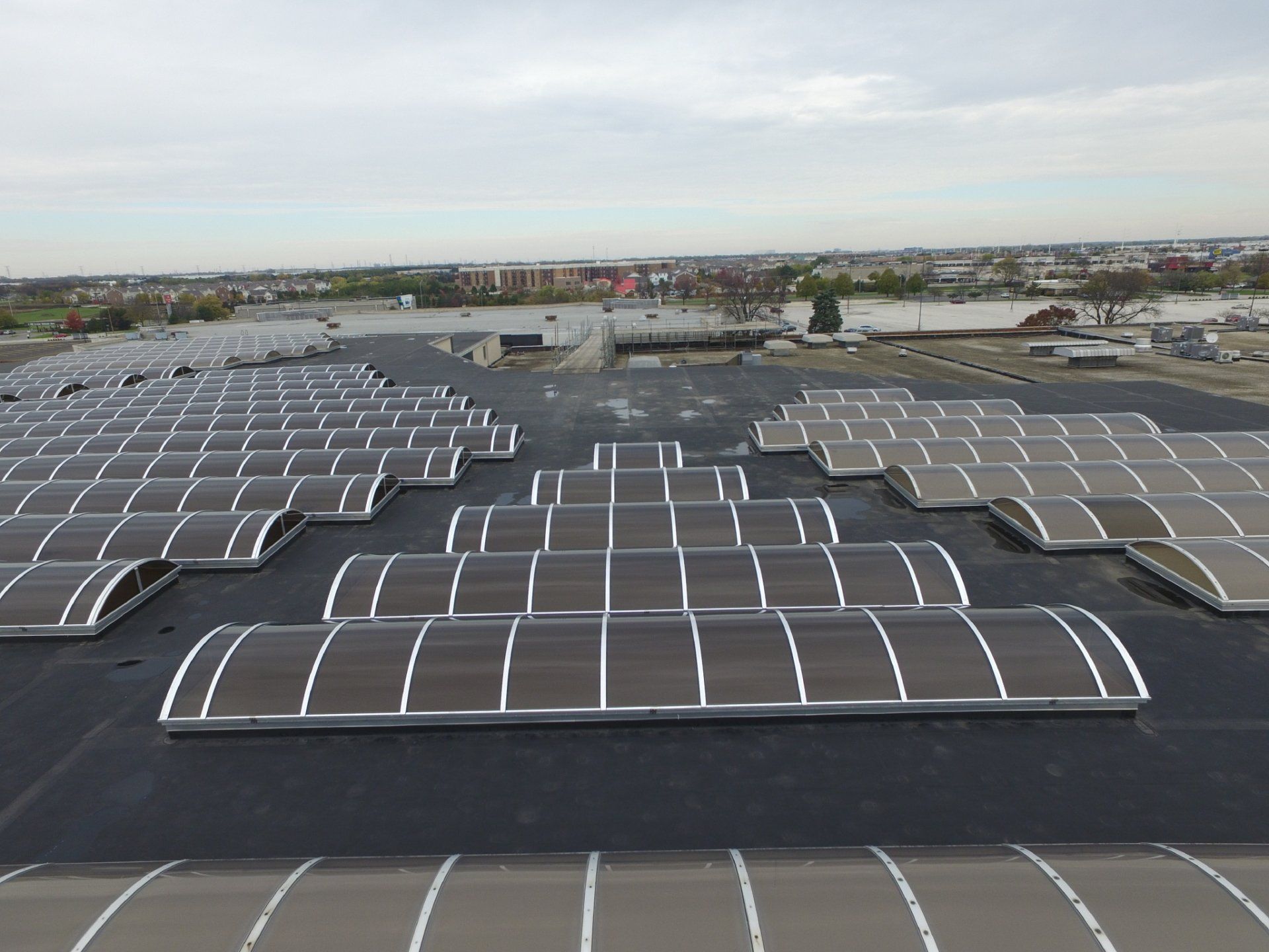 An aerial view of a large building with a lot of windows on the roof