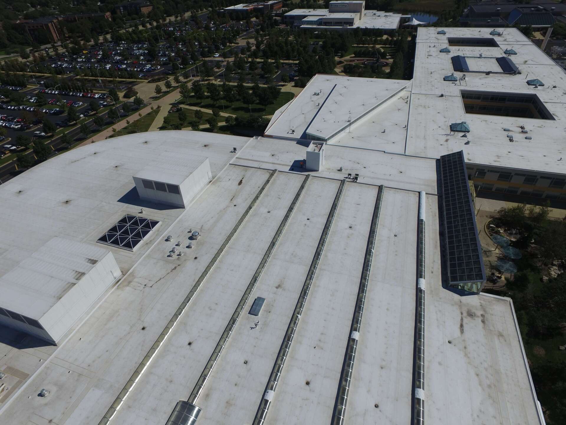 An aerial view of a large building with a white roof