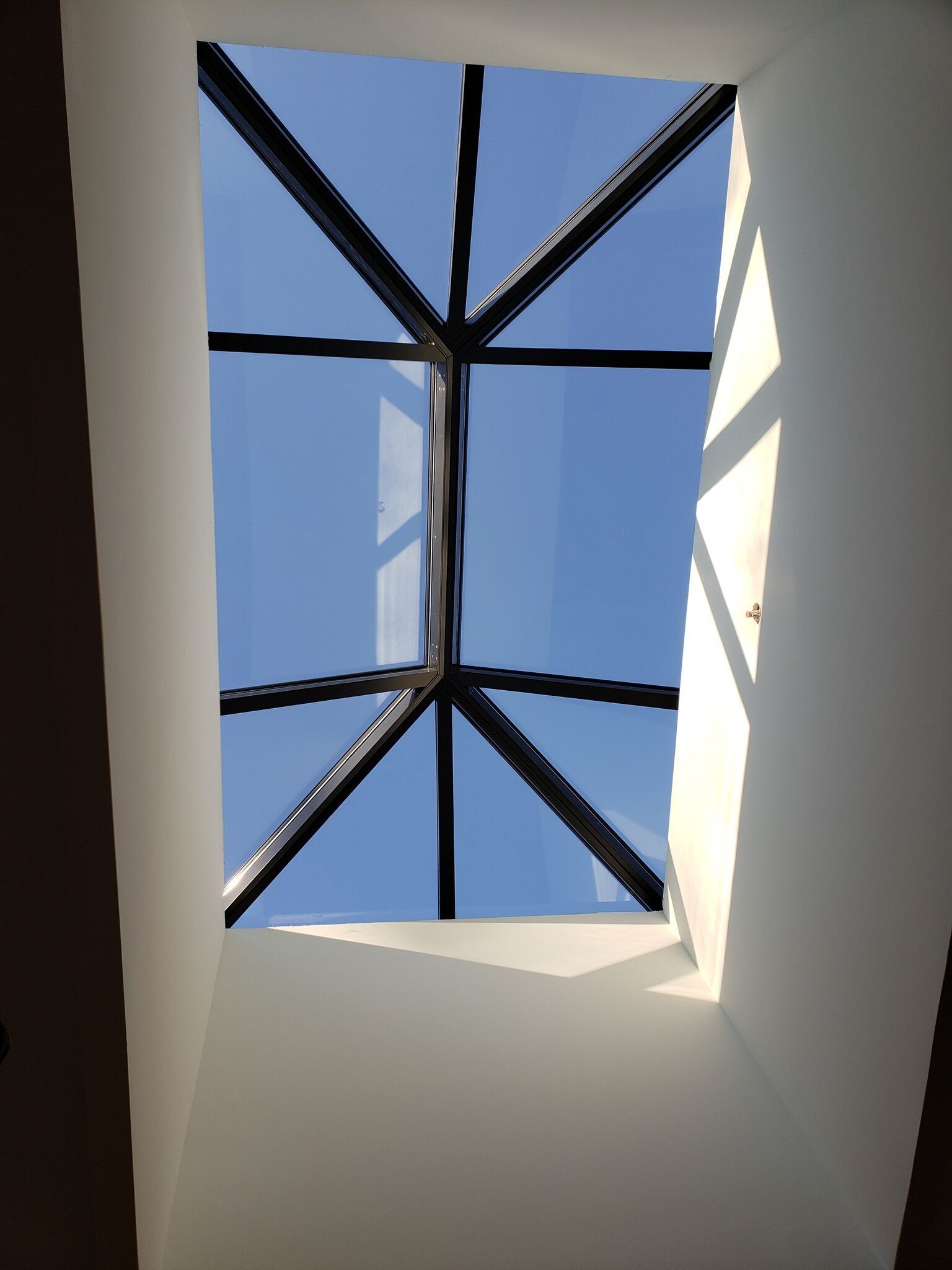 Looking up into a skylight with a blue sky behind it