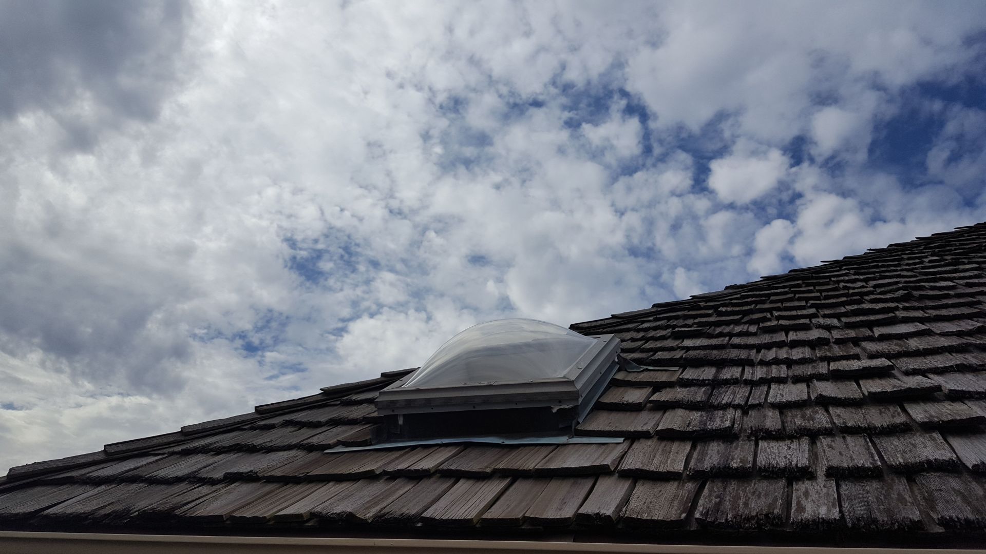 A wooden roof with a skylight on top of it.