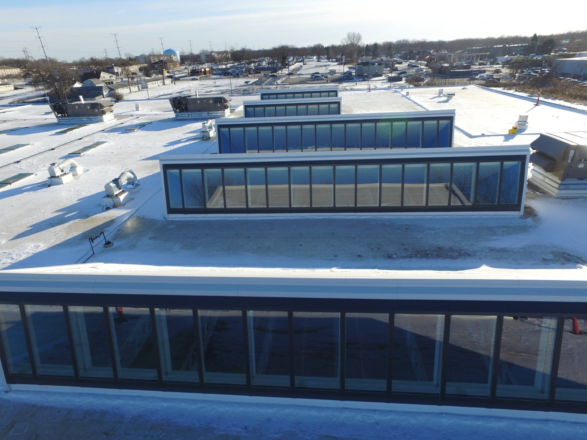 An aerial view of a building with snow on the roof.