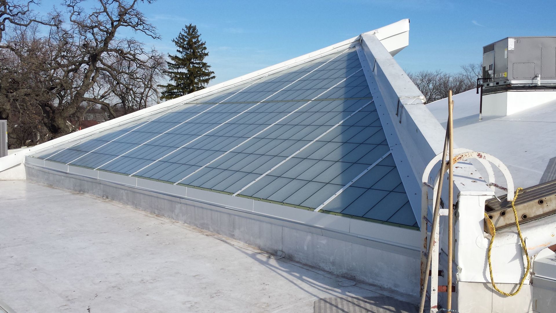 A white roof with a triangle shaped skylight on it