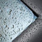 A close up of water drops on a metal surface.