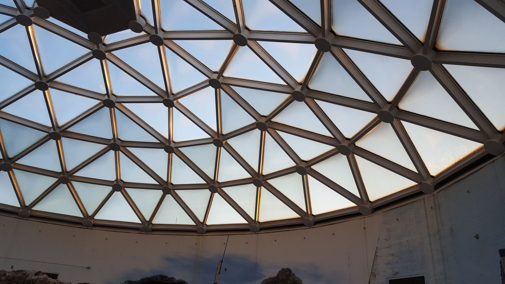 Looking up at a dome ceiling with a blue sky in the background