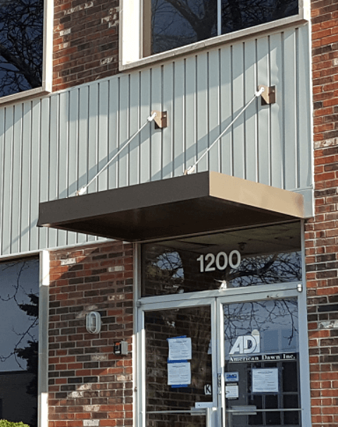 Brick building with canopy labeled '1200', custom flashing and trim by Roofing Solutions in Chicago
