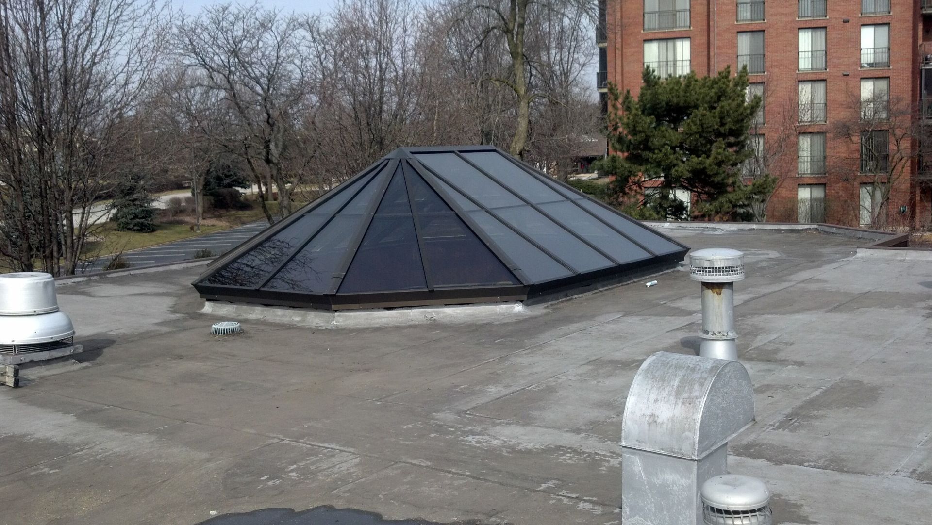 A roof with a dome on it and a brick building in the background