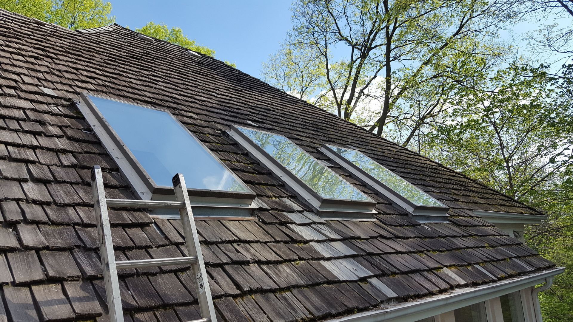 There are three skylights on the roof of a house.