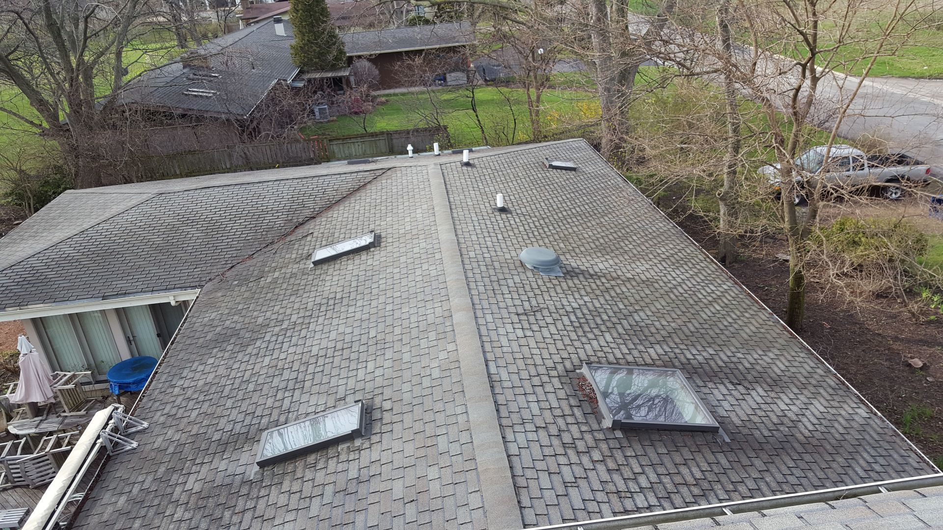 An aerial view of a roof with skylights and a truck parked in the background.